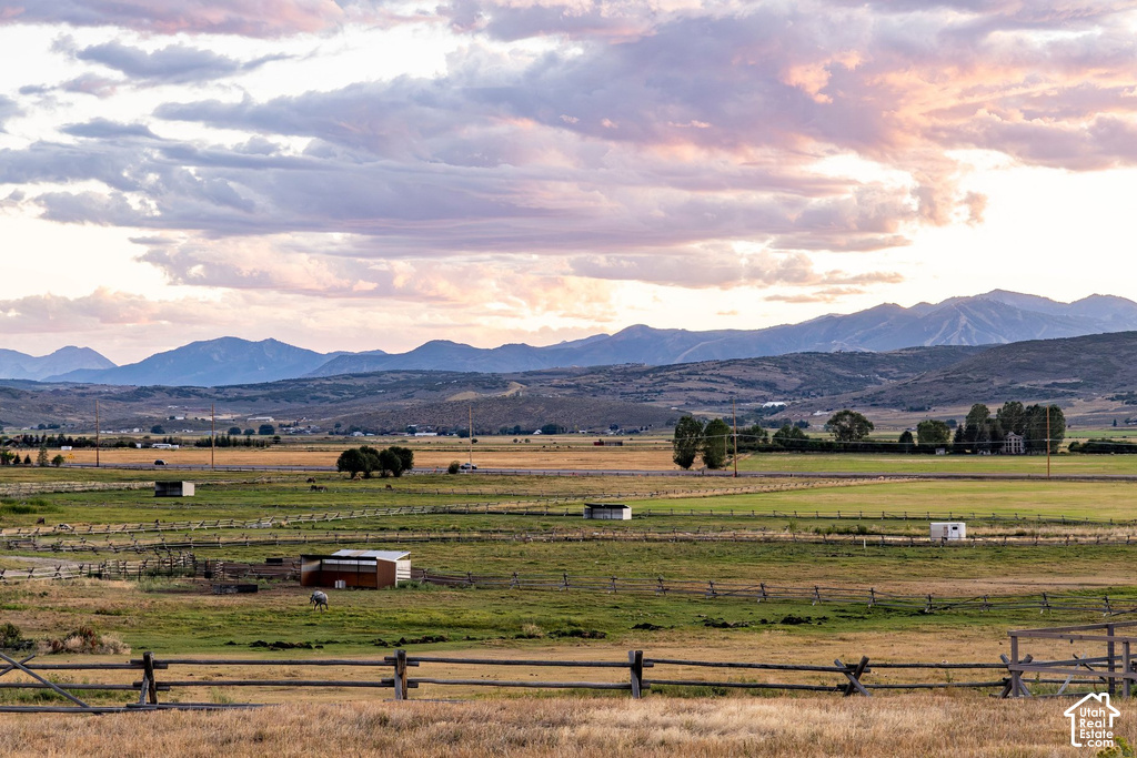 Expansive rural landscape featuring distant mountain ranges, natural terrain, and scattered structures
