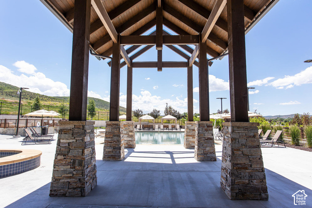 Open-air pavilion featuring exposed wood beams and stone-wrapped support columns