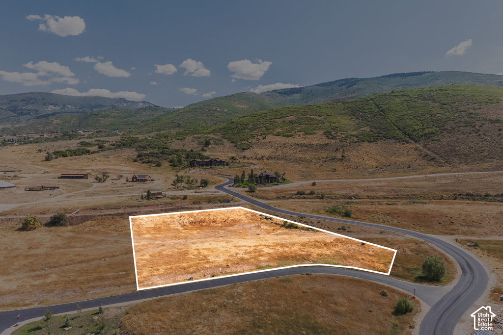 Cleared lot featuring direct road frontage and a mountainous backdrop