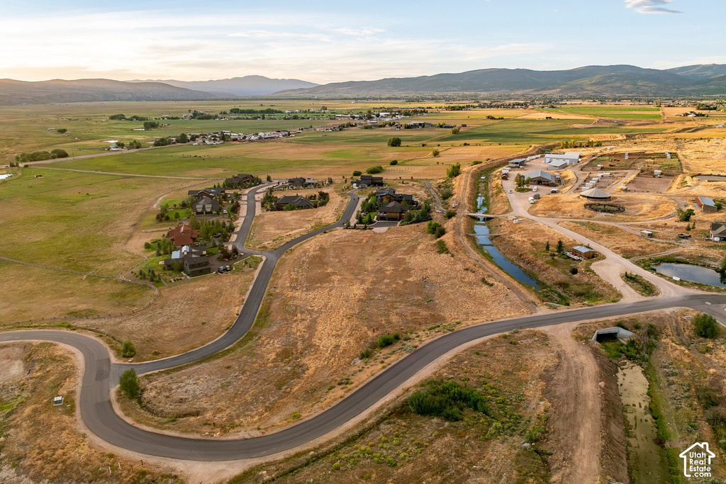 Expansive rural landscape with established residential development, paved roadways, and a natural waterway