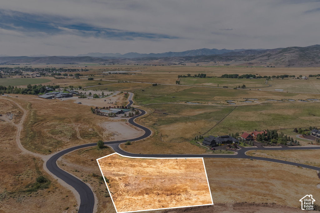 Expansive land parcel with surrounding paved roads and distant mountain backdrop