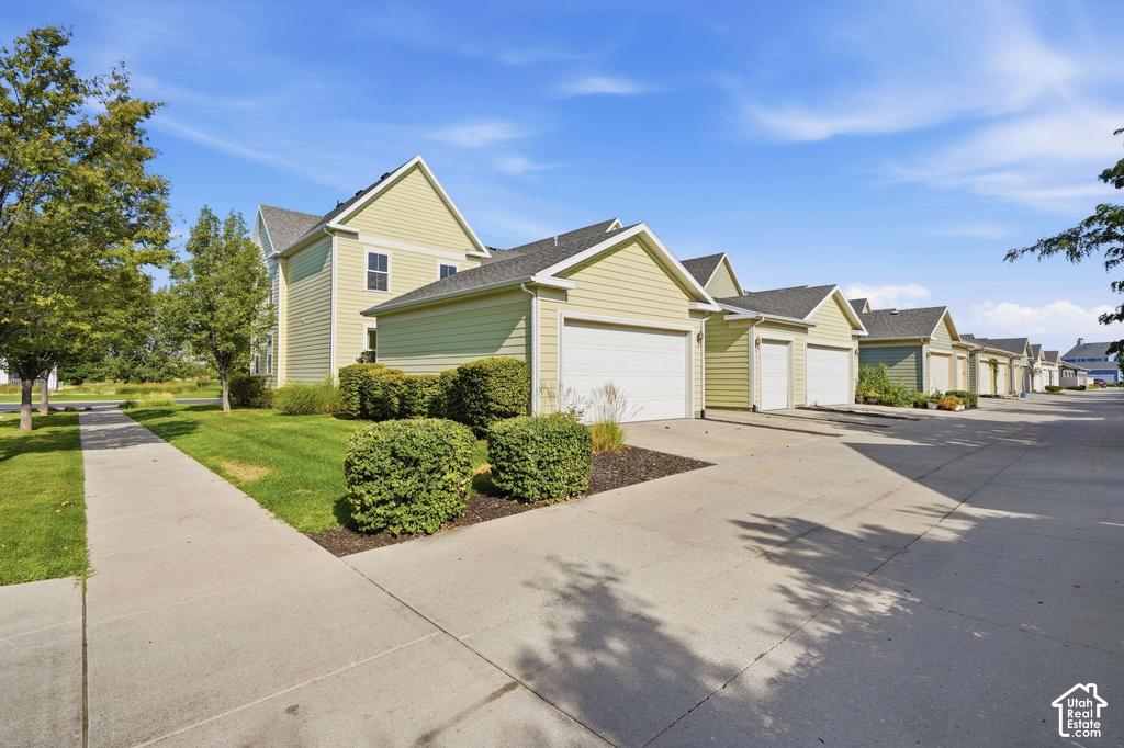 Multiple garages with light green siding and white garage doors