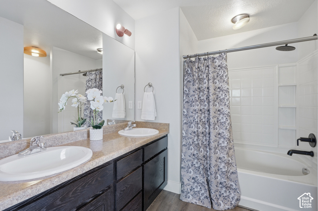 Dual vanity with white oval sinks, dark wood-finish cabinetry, and a textured countertop