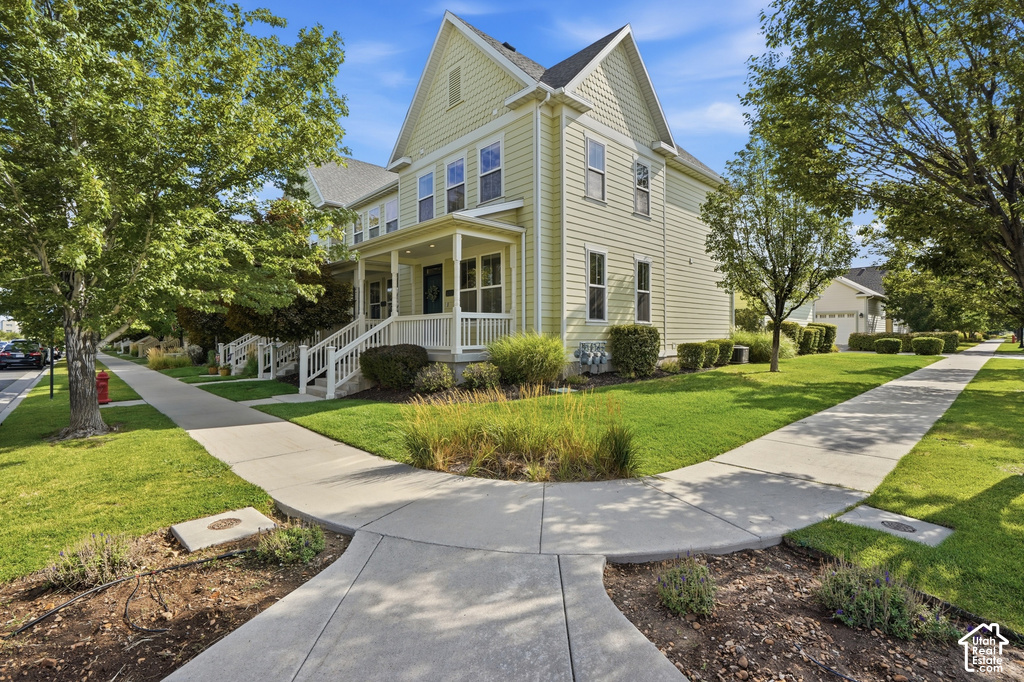 Two-story residence with light-colored siding, a covered front porch with white railings, and a gabled roofline