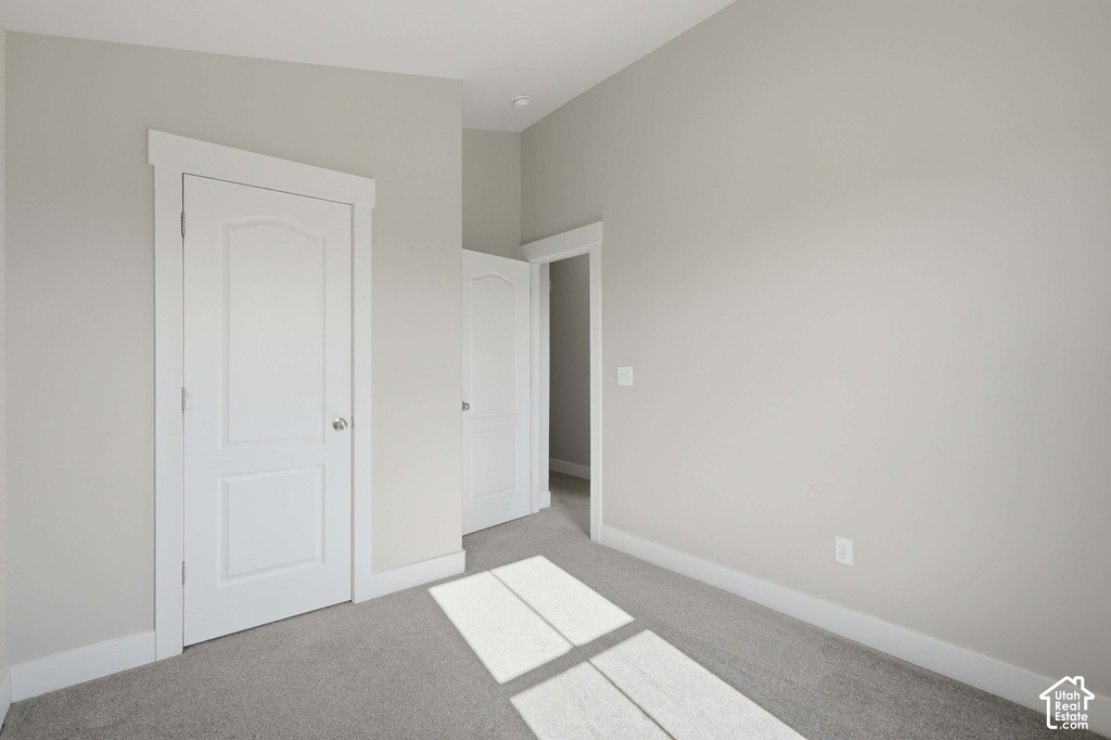 Neutral wall paint, white trim, two panel interior doors, and carpeted flooring
