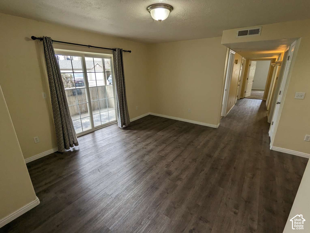 Wood-finish flooring throughout, with a sliding glass door leading to an outdoor patio