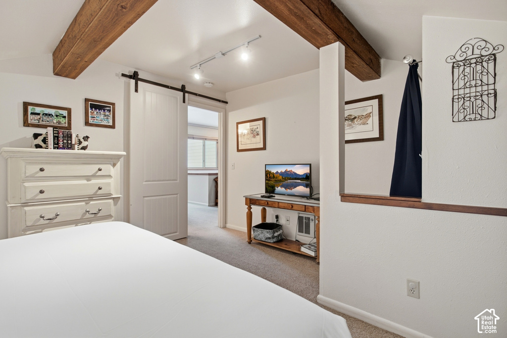 Exposed wood ceiling beams, track lighting, barn-style sliding door, and a built-in wood-finish half-wall