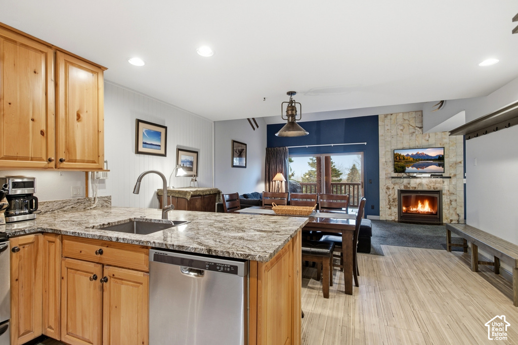 Kitchen featuring wood cabinetry, granite countertops, and a stainless steel dishwasher