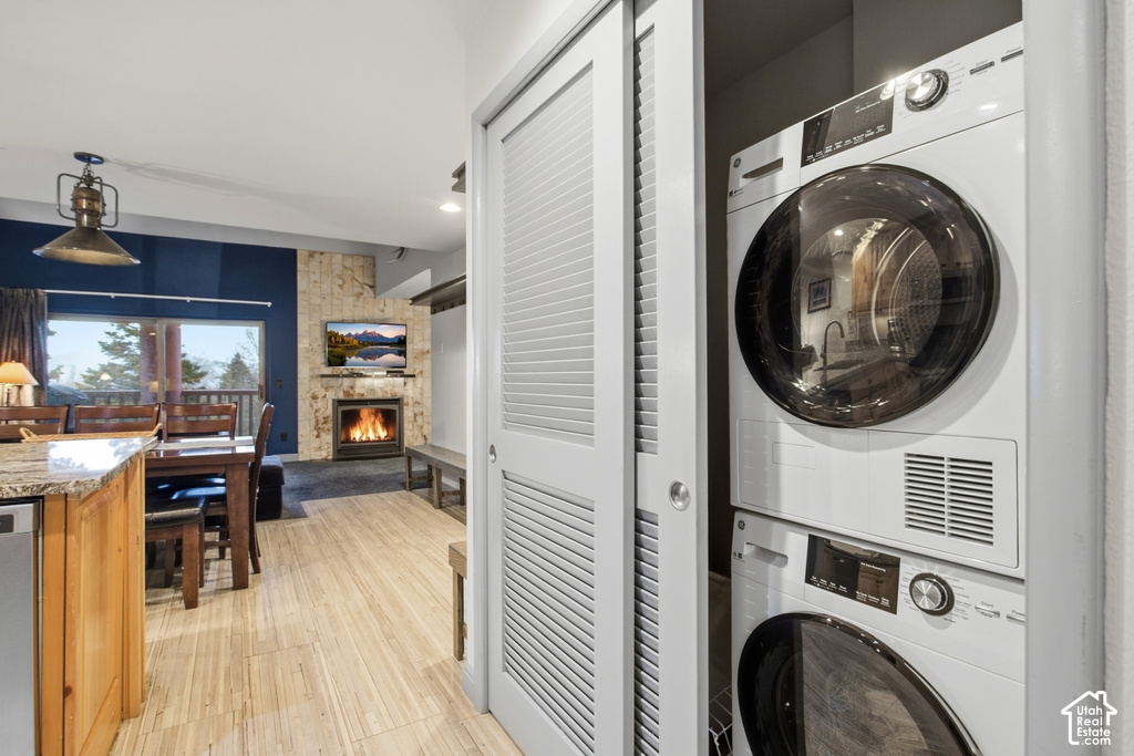 Stackable washer and dryer, wood-finish flooring, stone-clad fireplace, built-in shelving, and a large window