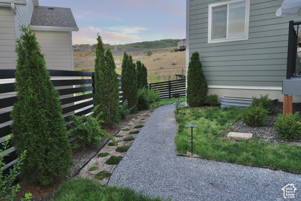 Gravel pathway with integrated lighting, bordered by manicured greenery