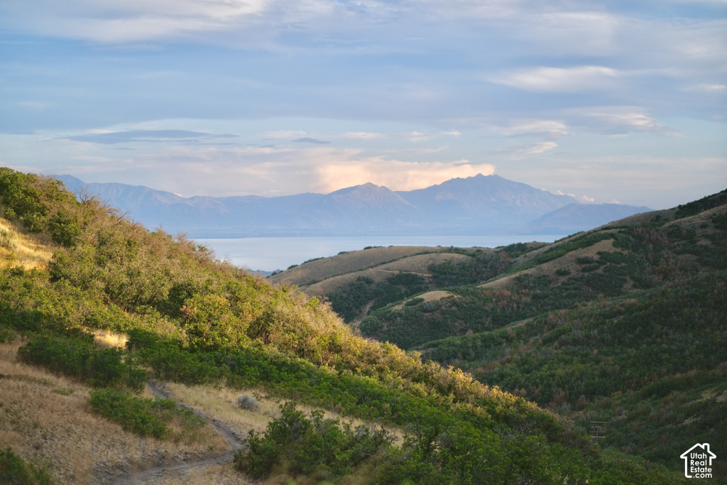 Mountainous terrain with natural vegetation, distant lake, and surrounding mountain ranges