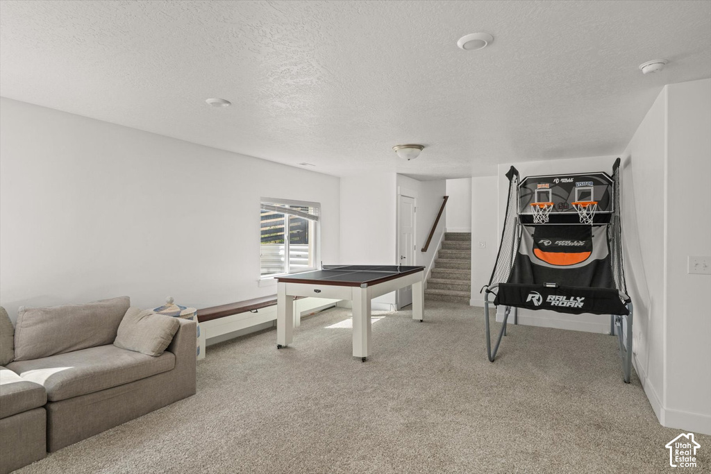 Recessed lighting illuminates a spacious room featuring light-toned carpeting