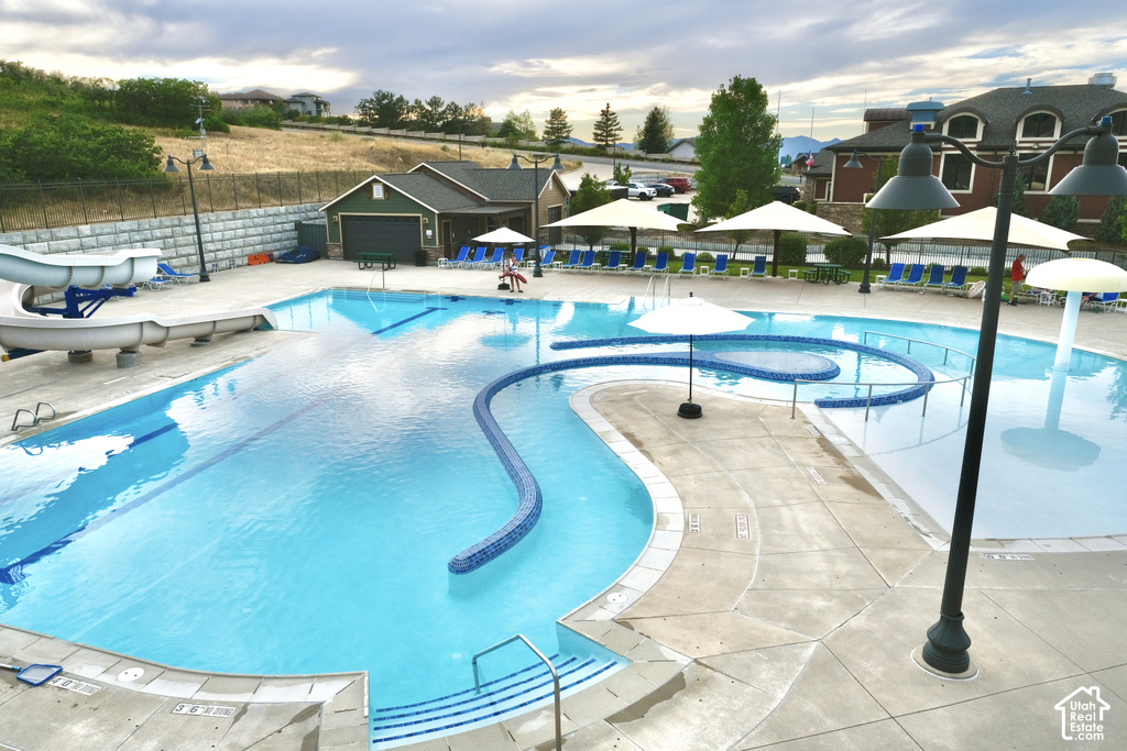 Community pool featuring a water slide, integrated wading area, and extensive concrete deck surround