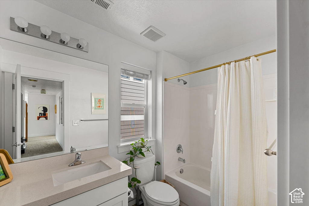 White vanity with an integrated rectangular sink, large frameless mirror, and a four-bulb vanity light fixture