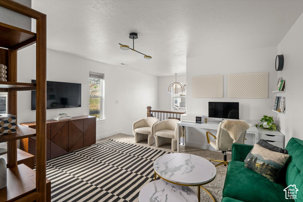 Carpeted flooring, contemporary light fixture, built-in shelving, white walls, and a window with natural light