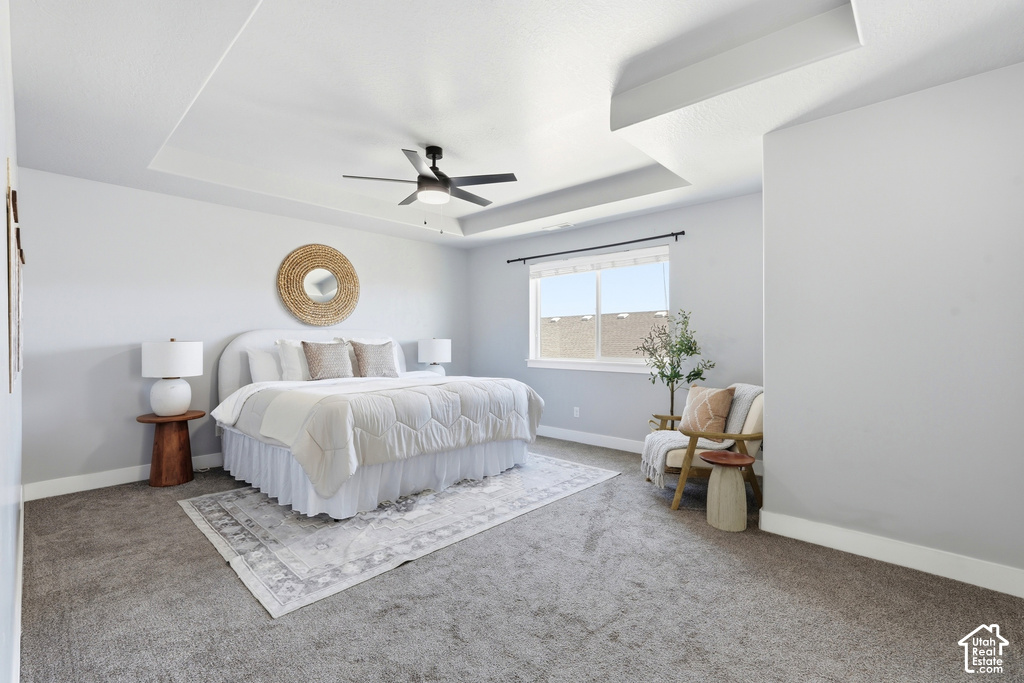 Tray ceiling, recessed lighting, ceiling fan, large window, and light gray wall paint