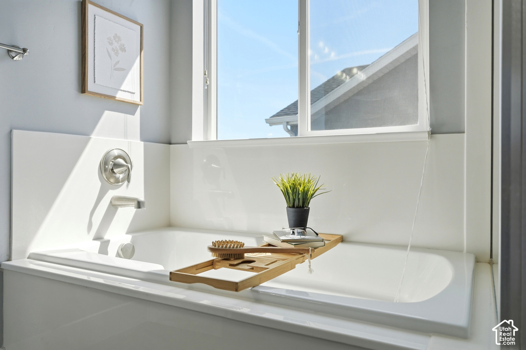 Built-in bathtub with a brushed nickel faucet and bright window