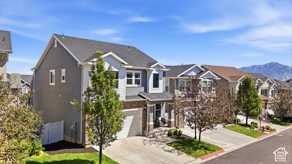 Contemporary residence with a two-car garage, stone and siding facade, and a covered front porch