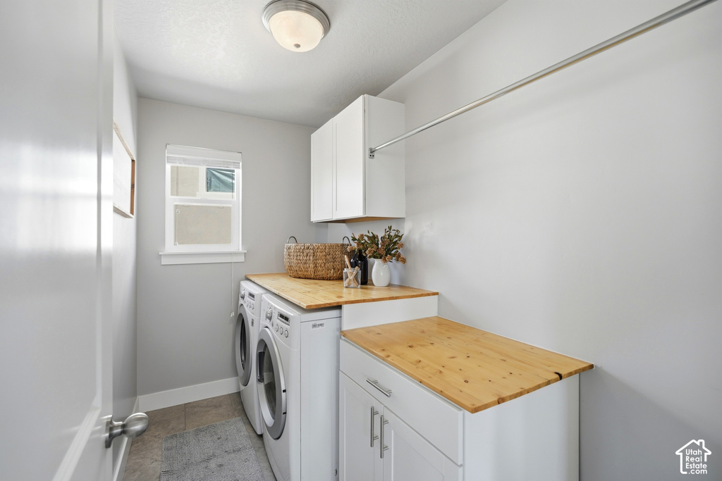 Laundry area featuring light wood-finish countertops, white cabinetry, a built-in hanging rod, and a window for natural illumination