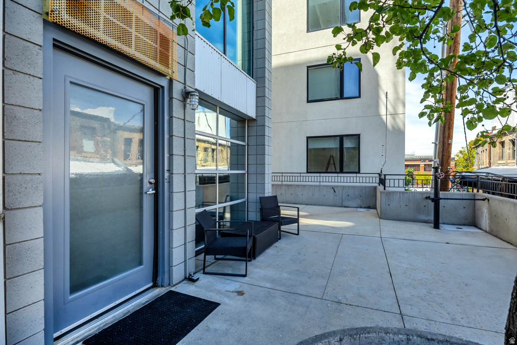 Concrete patio with block wall exterior and full-light entry door