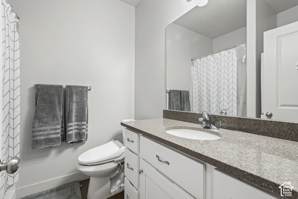 Vanity with integrated sink, stone-finish countertop, and white cabinetry with drawer pulls