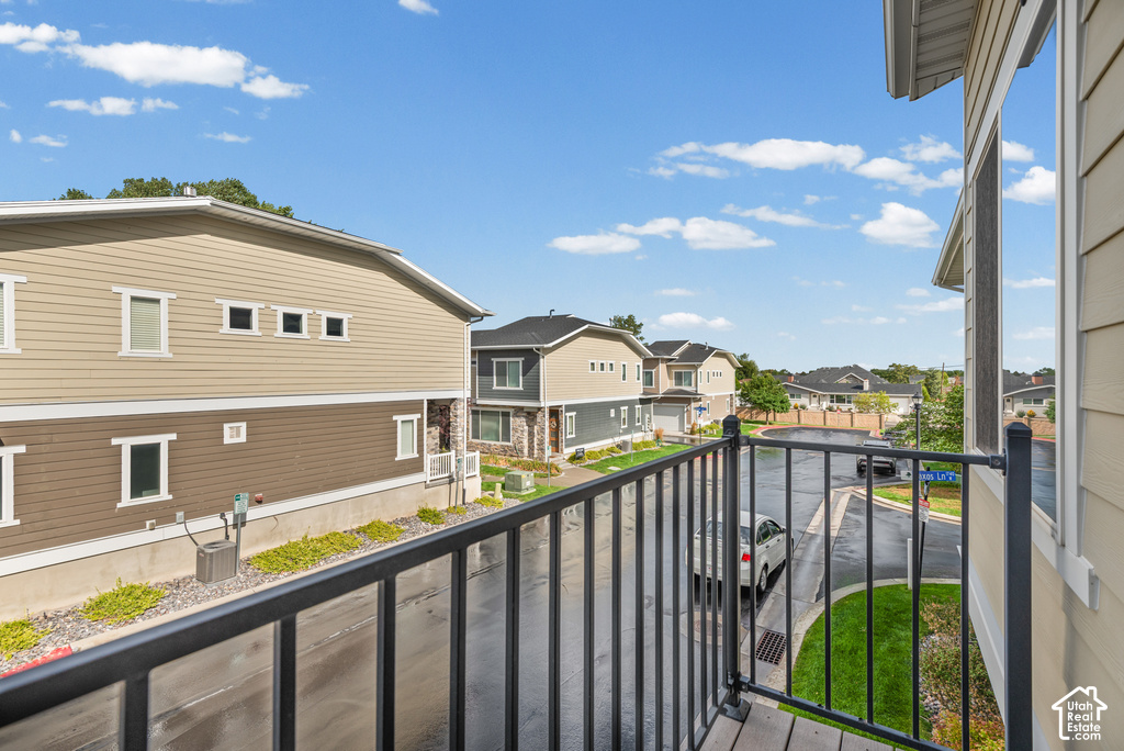 Exterior balcony with black metal railings and wood-finish flooring