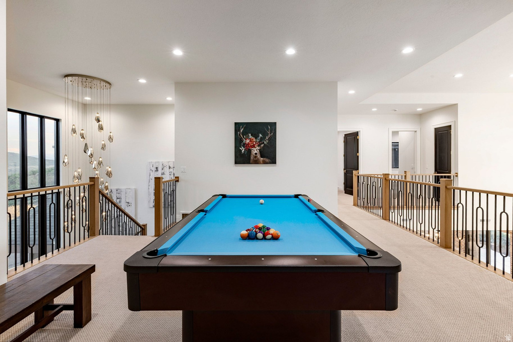 Spacious loft area featuring carpet flooring, recessed lighting, and a modern chandelier