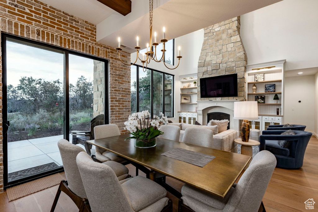 Expansive dining area with hardwood flooring, a candelabra-style chandelier, and a brick accent wall