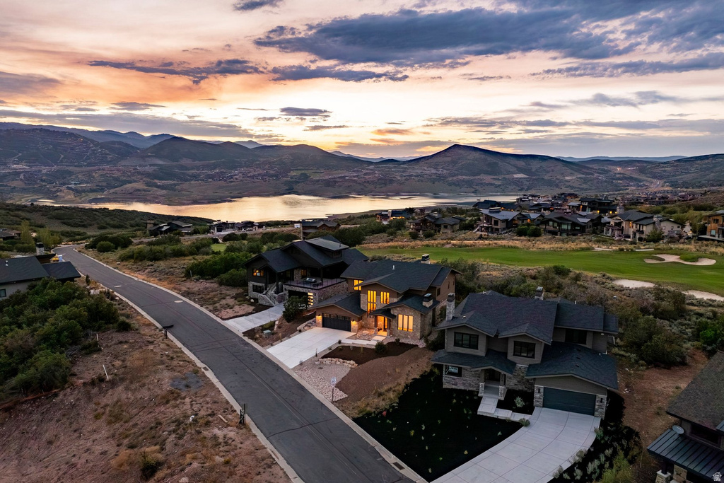 Terraced homes with stone and siding exteriors, concrete driveways, and sloped landscaping