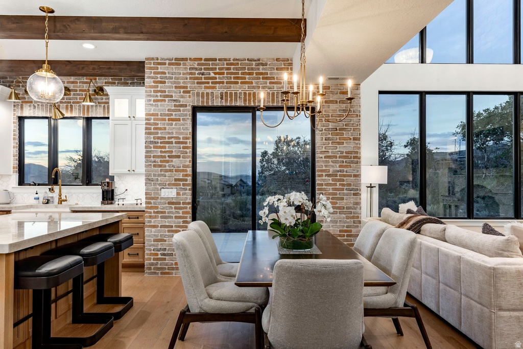 Open-concept living space with exposed wood beams and light wood-finish flooring