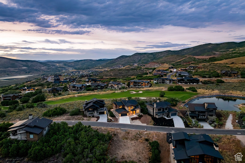 Expansive landscape with a golf course, a pond, and residential structures nestled into the hillsides