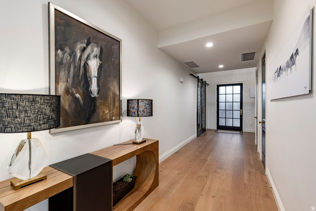 Wood-finish flooring, recessed lighting, and white wall finishes