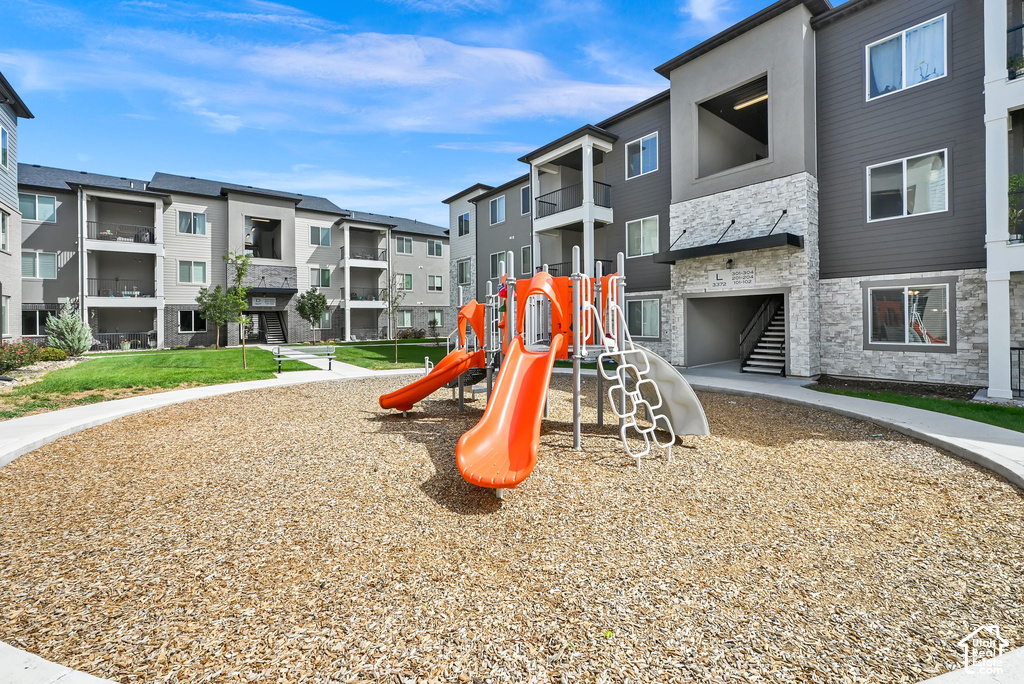 Outdoor play structure with slides and climbing features, surrounded by wood chip surfacing