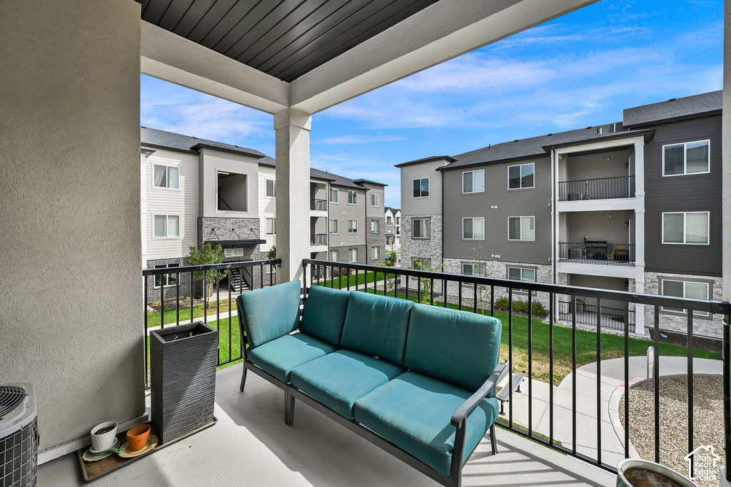 Private balcony with a painted concrete surface, supported by architectural columns, and featuring black metal railings