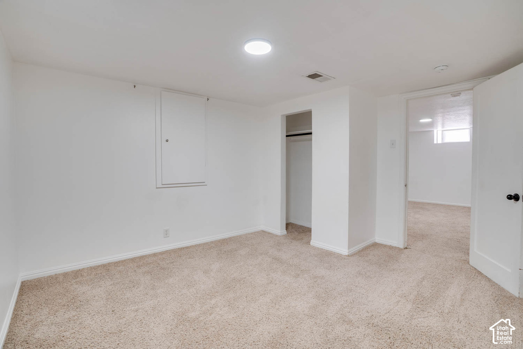 Recessed ceiling lighting, wall-to-wall carpeting, and an open closet with a hanging rod