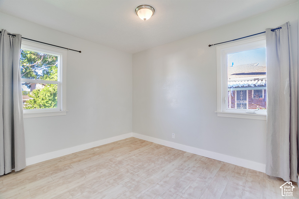 Light-toned wood-finish flooring, white walls, and a flush-mount ceiling light