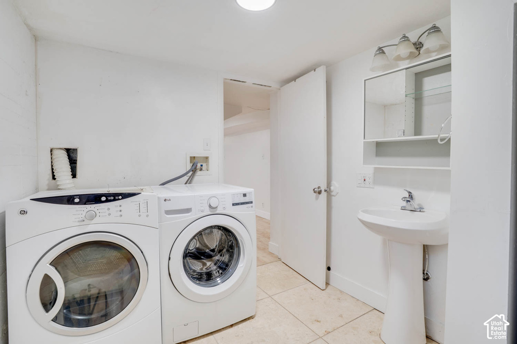 Utility area featuring floor tiling, pedestal sink with a medicine cabinet, and overhead lighting