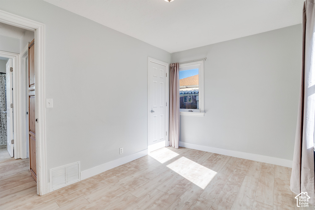 Light-toned wood-finish flooring, white trim, and a built-in wood-finish cabinet