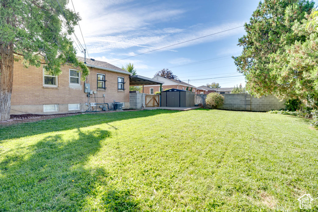 Expansive backyard featuring a manicured lawn, mature trees, and a brick exterior dwelling