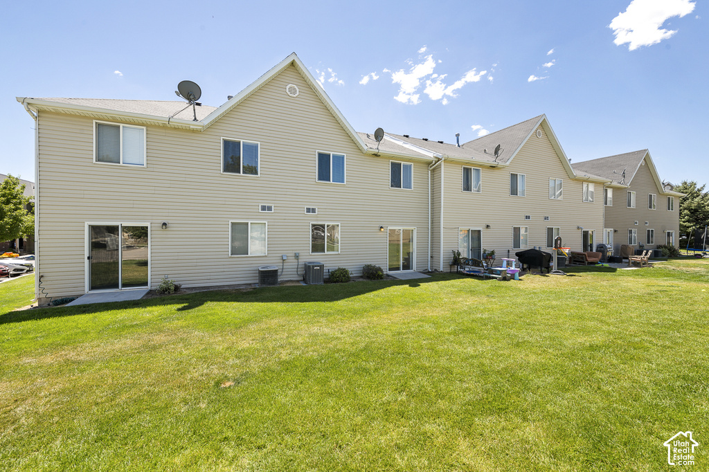 Light-colored siding exterior, multiple sliding glass patio doors, gable rooflines, and a grassy outdoor area