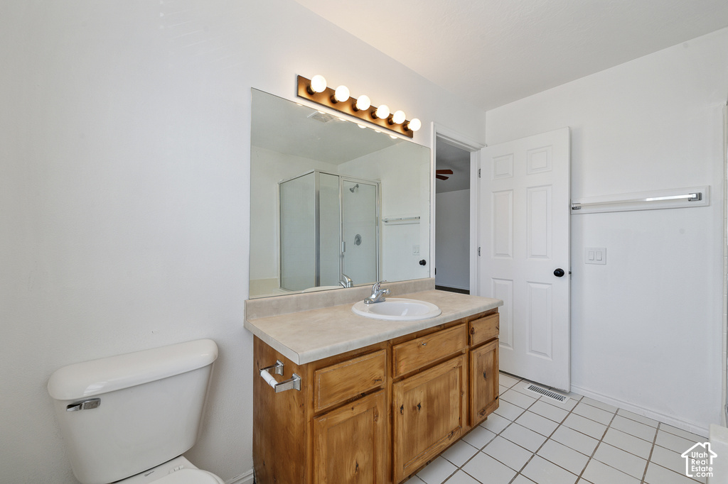Bathroom featuring a wood-finish vanity with an integrated sink, a large wall mirror, and overhead vanity lighting