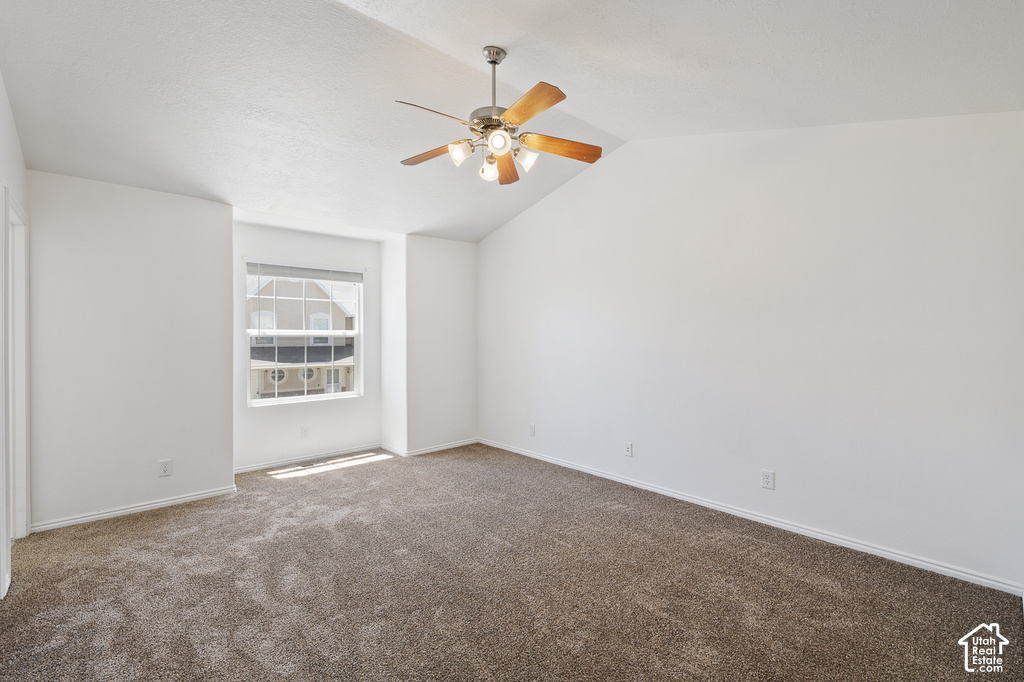 Vaulted ceilings, a ceiling fan with integrated lighting, and a neutral carpeted floor