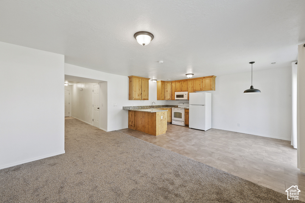 Kitchen featuring wood cabinetry, white appliances, and a breakfast bar