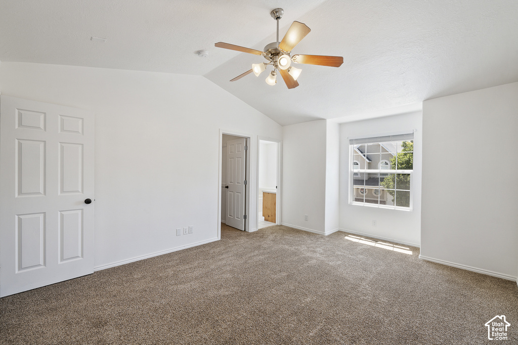 Vaulted ceiling, ceiling fan with integrated lighting, carpeted flooring, paneled interior doors, and a window with blinds
