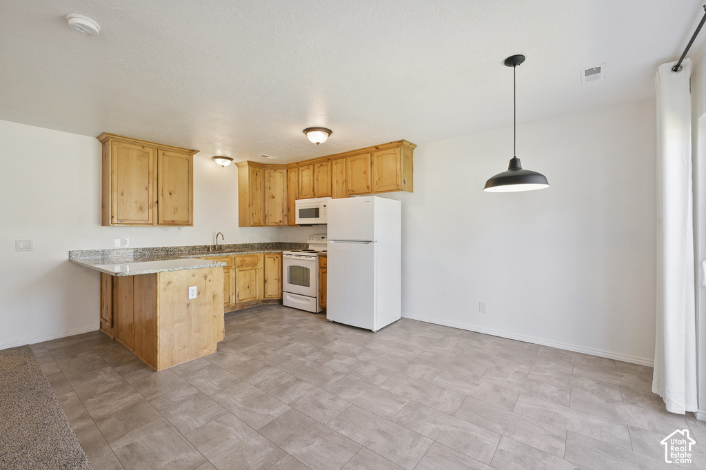 Light wood cabinetry, light-toned granite-style countertops, white appliances, tile flooring, and a pendant light fixture