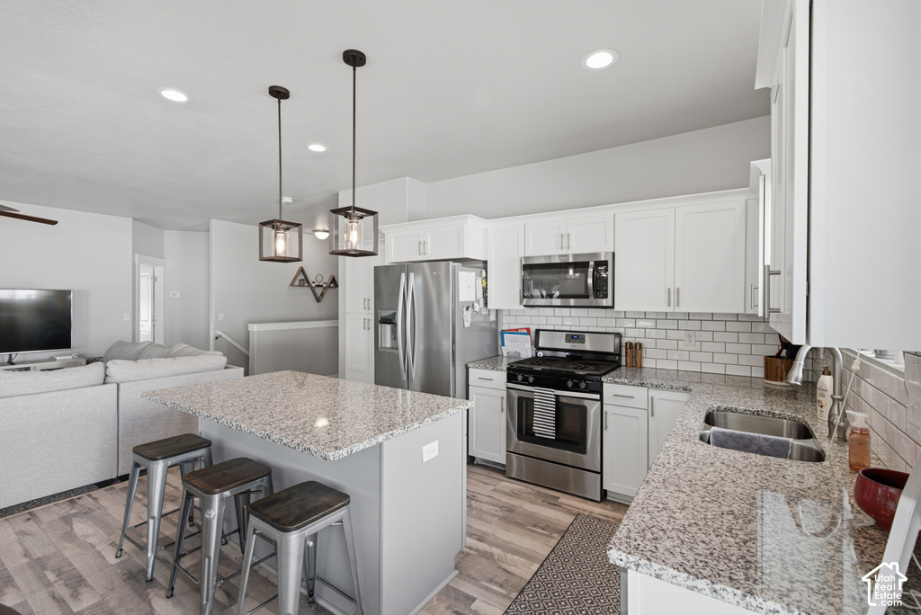 Kitchen featuring white shaker cabinetry, stainless steel appliances, granite countertops, and subway tile backsplash