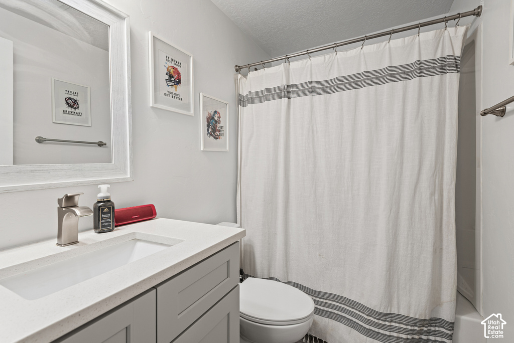 Vanity with integrated sink, brushed nickel faucet, framed mirror, and a wall-mounted towel bar