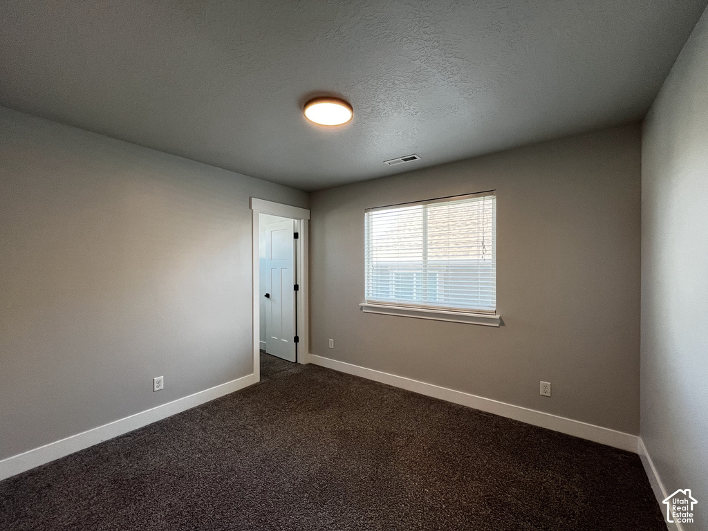 Recessed window with white blinds, neutral wall paint, white trim, dark textured carpeting, and a flush-mount ceiling light fixture
