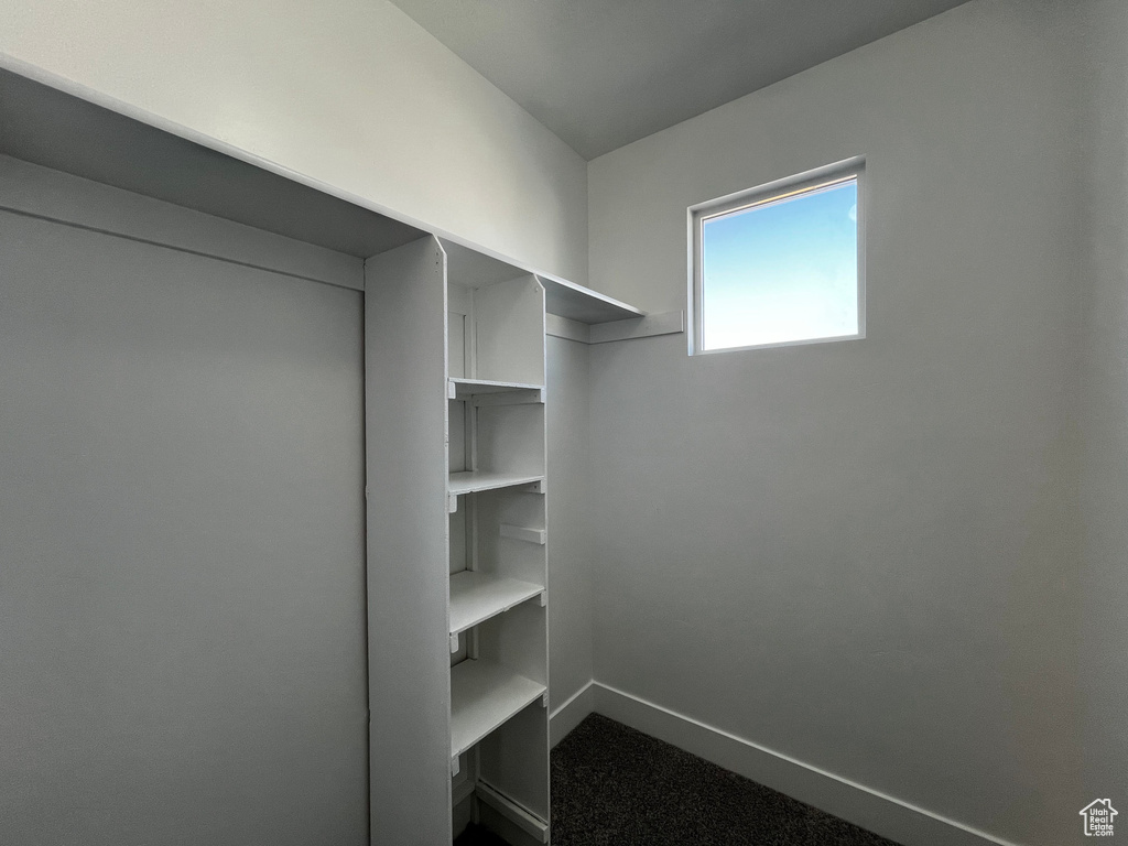Built-in shelving, white walls, and a single window with white trim