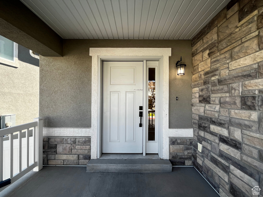 Entryway featuring a paneled door, sidelight, and stone veneer accent wall